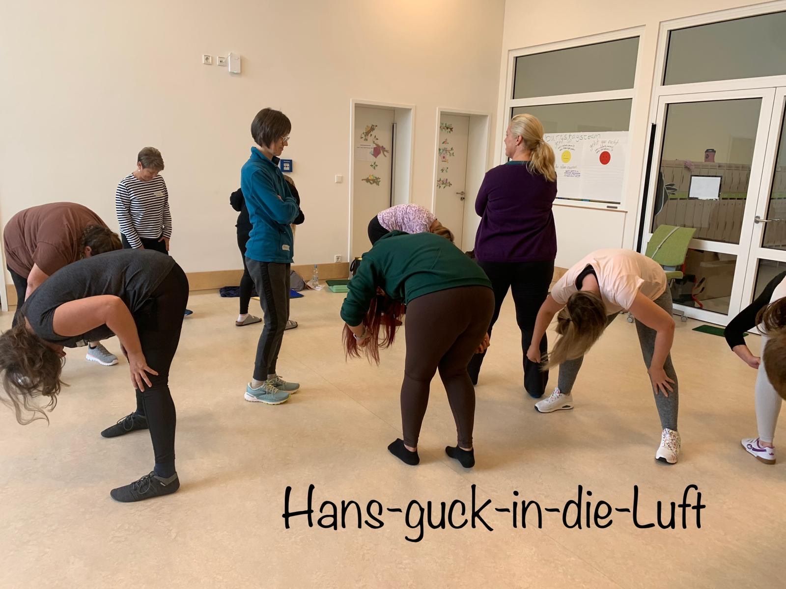 Fachkräfte probieren in einem hellen Raum gemeinsam eine Bewegungsübung aus