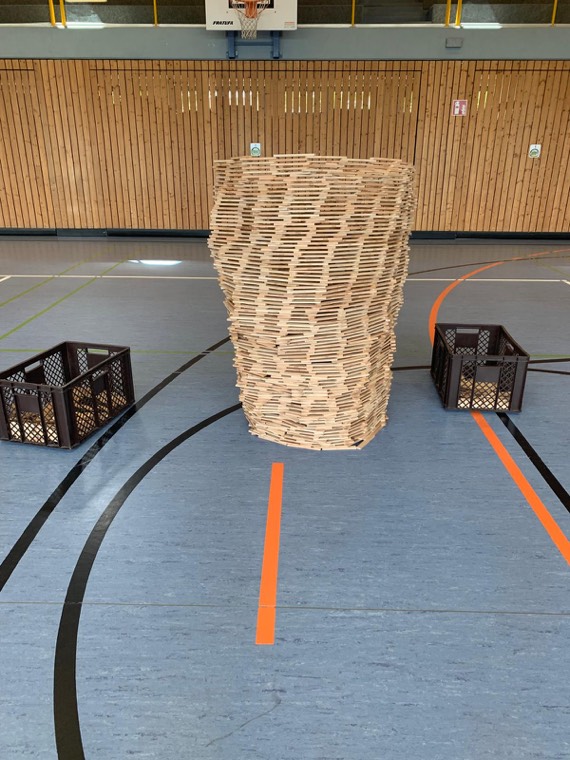Ein großer Turm aus Holzbausteinen in der Turnhalle