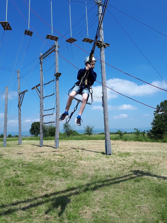 Junge schwingt auf der Riesenschaukel vor blauem Himmel